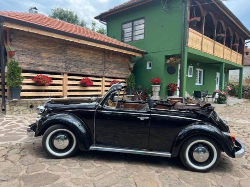 an old black car parked in front of a house at Temački konaci in Pirot