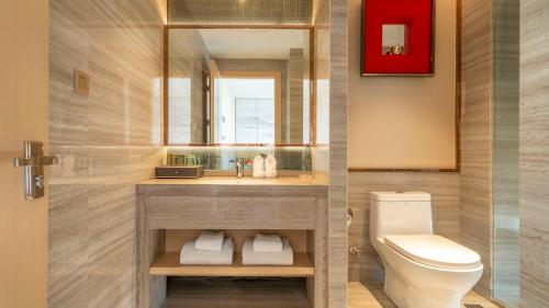 a bathroom with a sink and a toilet at Weilai J Hotel Kunming New Luoshuiwan Branch in Kunming