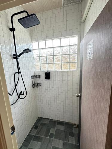 a bathroom with a shower with a window at Moon house Beach Hostel in Haad Rin