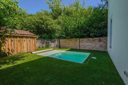 une cour avec une piscine sur gazon dans l'établissement Promo 20 pourcent - Grand écran - piscine - baby foot - idéal famille ou amis, à Labouheyre