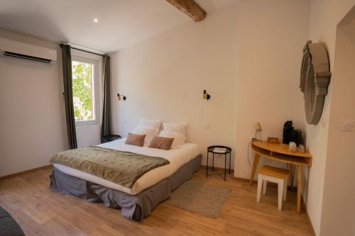 une chambre avec un lit, une table et une fenêtre dans l'établissement Hôtel d'Angleterre, Salon-de-Provence, à Salon-de-Provence