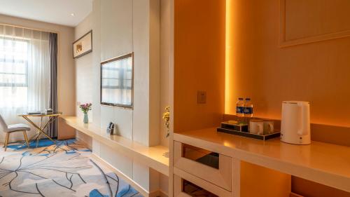 a hotel room with a counter and a room at Weilai J Hotel Kunming New Luoshuiwan Branch in Kunming