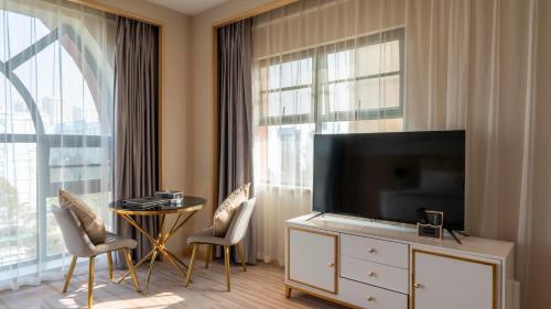 a living room with a tv and a large window at Weilai J Hotel Kunming New Luoshuiwan Branch in Kunming