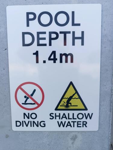 a sign that says pool depth am and no shallow water at Blue Aura Beach villa Larnaca in Pervolia