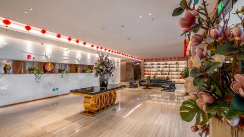 a large room with a lobby with flowers on the wall at Weilai J Hotel Kunming New Luoshuiwan Branch in Kunming