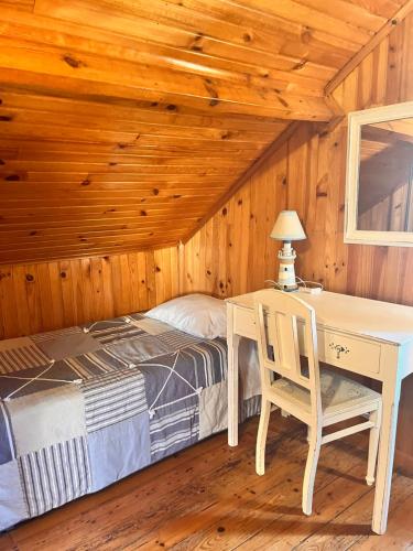 a bedroom with a bed and a table and a desk at Pensão José das Hortas in Costa Nova