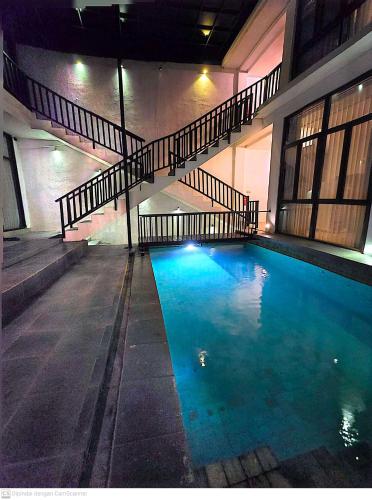 una piscina con escalera en un edificio en Serenity Nirvana Palace - Jimbaran Hostel, en Jimbaran