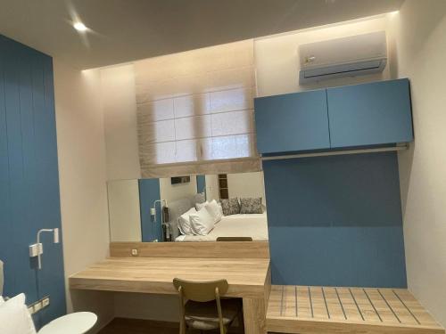 a room with a desk and a bed in a mirror at Modern Apartment, Few Meters from the Beach in Néa Koróni
