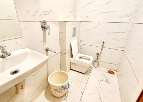 a white bathroom with a sink and a toilet at HOTEL APPLE G STAY Near Shri Mahakaleshwar Jyotirlinga Temple - Fully Air Conditioned Hotel - Free Wifi & Parking - Excellent Customer Service Awarded in Ujjain