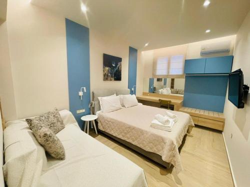 a hotel room with a bed and a couch at Modern Apartment, Few Meters from the Beach in Néa Koróni