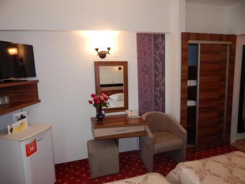 a hotel room with a desk and a mirror at Hotel Traian Caciulata in Călimăneşti
