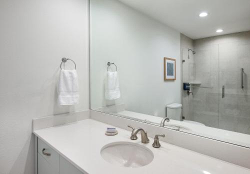 a white bathroom with a sink and a mirror at Islander Resort in Islamorada