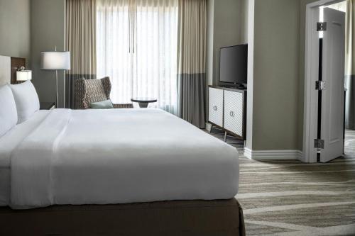 a hotel room with a large bed and a television at Renaissance Tampa International Plaza Hotel in Tampa