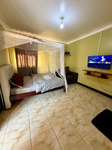 a room with a bed and a tv in it at Muni Residences Ug in Arua