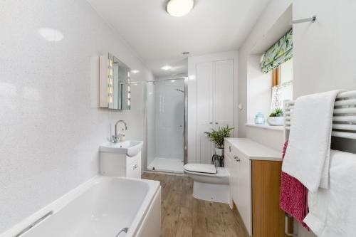 Un baño con bañera, inodoro y lavabo. en Upper Tallet at Accott Manor, en West Buckland