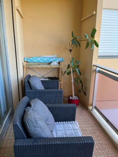 2 chaises assises sur un balcon avec une plante dans l'établissement Studio Mila, à Nice