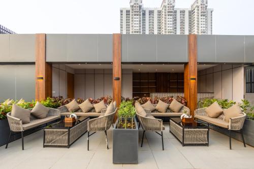 a hotel lobby with couches and tables and a building at Saltstayz Autograph - Advant & Sector 144 in Noida