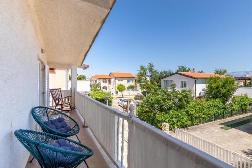 een balkon met 2 stoelen en uitzicht op een straat bij Apartment Siranovic in Batalaži