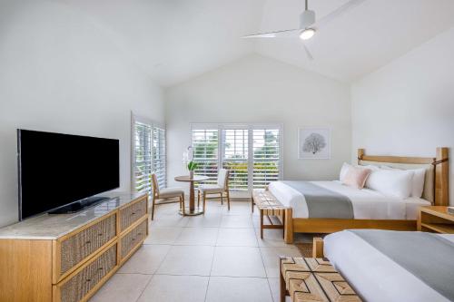 a bedroom with a bed and a tv and a bed and a bed at Islander Resort in Islamorada