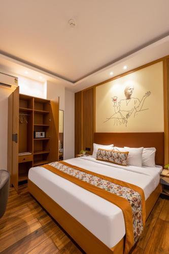 a bedroom with a large bed with a painting on the wall at Saltstayz Autograph - Advant & Sector 144 in Noida