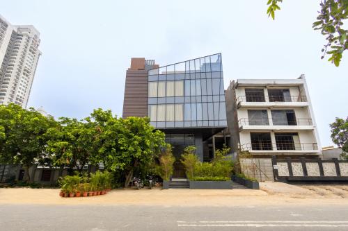 a tall building with trees in front of it at Saltstayz Autograph - Advant & Sector 144 in Noida