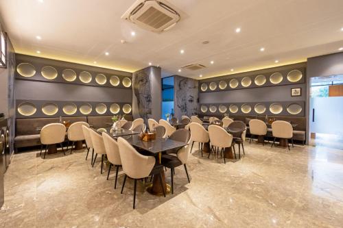 a dining room with tables and chairs and wine barrels at Saltstayz Autograph - Advant & Sector 144 in Noida