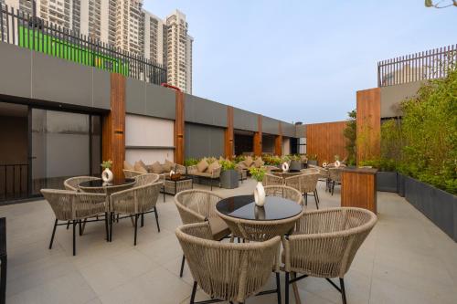 a patio with tables and chairs on a building at Saltstayz Autograph - Advant & Sector 144 in Noida