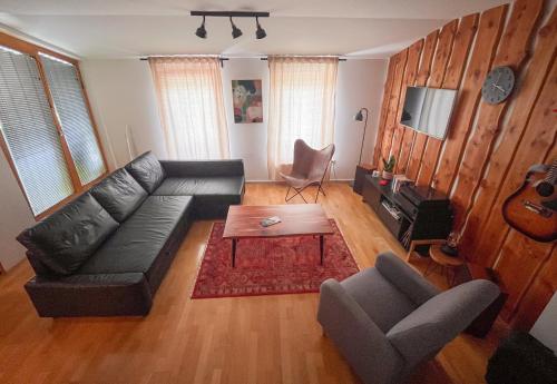 a living room with a black couch and a table at APARTMA JEREBIKA ŠT. 20 in Pohorje
