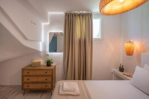 a bedroom with a bed and a dresser and a mirror at Depis private villas Plaka Naxos in Plaka