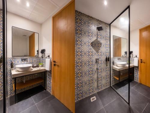 a bathroom with two sinks and two mirrors at Saltstayz Autograph - Advant & Sector 144 in Noida