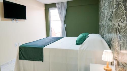a bedroom with a bed with a blue pillow on it at Davila Flat Hotel in Fortaleza
