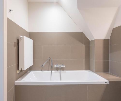 a bathroom with a bath tub with a sink at HuysHoeve in Knokke-Heist
