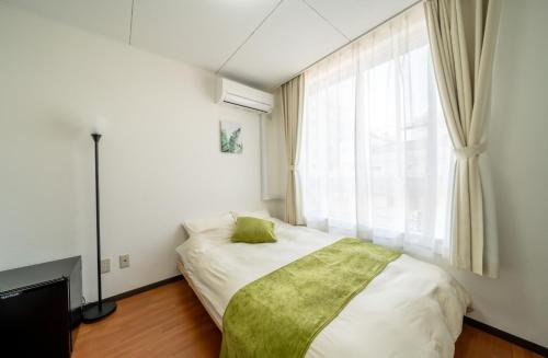 a bedroom with a bed and a large window at Casa G,S, - Vacation STAY 52558v in Osaka