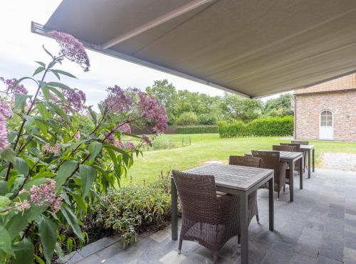 a patio with tables and chairs and flowers at HuysHoeve in Knokke-Heist