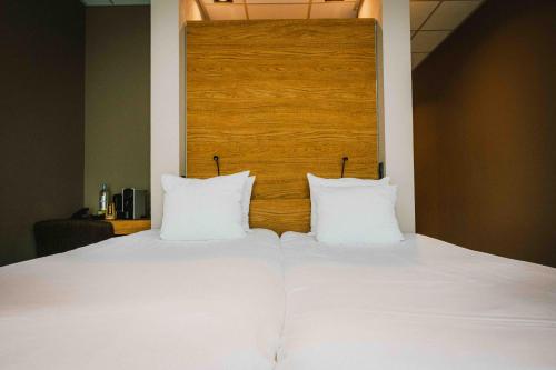 a bed with two white pillows on top of it at Hotel & Wellness Zuiver in Amsterdam
