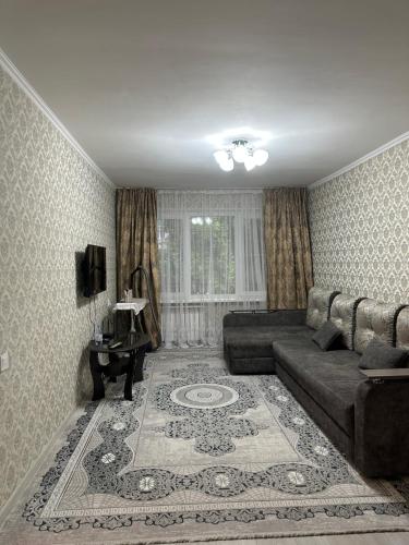 a living room with a couch and a rug at Квартира в районе Esentai Mall in Almaty