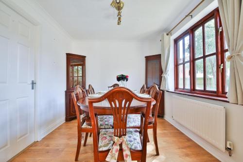 une salle à manger avec une table et des chaises et une fenêtre dans l'établissement Homely 5 Bed House - 15 Mins to Cardiff City, à Cardiff