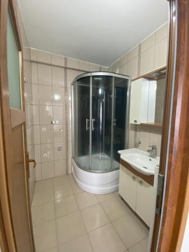 un bagno con doccia in vetro e lavandino di Blue 61 Residence a Pelitli