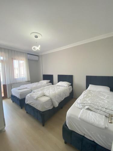 3 posti letto in una stanza con pareti bianche di Blue 61 Residence a Pelitli