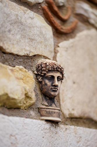 a statue of a head on the side of a wall at Zoi Urla in Urla