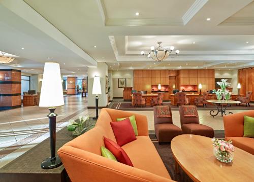 a hotel lobby with orange chairs and a table at The Pamodzi Hotel in Lusaka