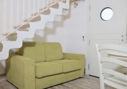 a living room with a green couch and stairs at CasaMarchi in Sottomarina