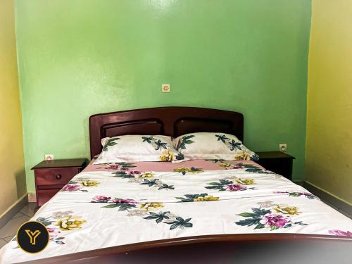 zieloną sypialnię z łóżkiem z kwiatami w obiekcie Appartement Bruno, 2 Chambres w mieście Jaunde