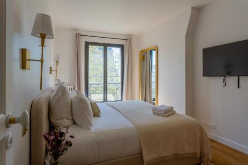 une chambre blanche avec un lit avec une fenêtre dans l'établissement Rive Gauche Light and Elegance, à Paris