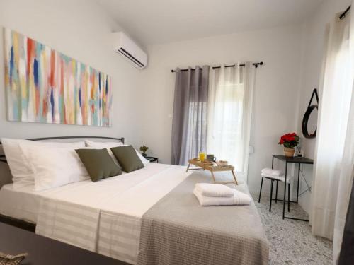 a bedroom with a large white bed and a window at Blue Hotel Apartments in Ierissos
