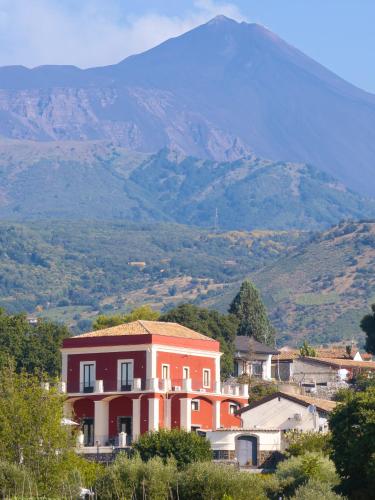 a house on a hill with a mountain in the background at Badimà - Villa con piscina in Aci SantʼAntonio