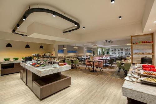 a large kitchen with a cafeteria with tables and chairs at Sterling Nainital in Nainital