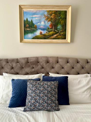 un tableau au-dessus d'un lit avec des oreillers bleus et blancs dans l'établissement Appartement d exception 100m2 avec Parking - Centre historique, à Chambéry