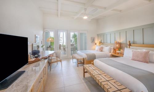 a hotel room with two beds and a flat screen tv at Islander Resort in Islamorada