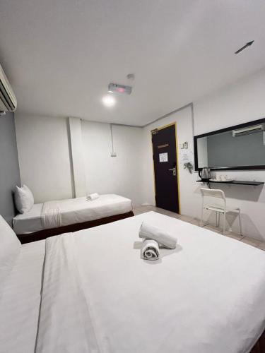 a room with two beds and a flat screen tv at Hotel Seroja in Labuan